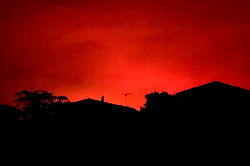 This Tuesday, Dec. 31, 2019, photo provided by Twitter user @AvaTheHuman shows red sky from wildfires burning, in Victoria, Australia. On Tuesday morning, 4,000 people in the coastal town of Mallacoota fled to the shore as winds pushed a fire toward their homes under a sky darkened by smoke and turned blood-red by flames.