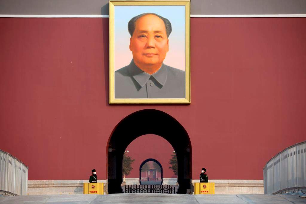Chinese paramilitary police wear face masks as they stand guard beneath the large portrait of Chinese leader Mao Zedong at Tiananmen Gate adjacent to Tiananmen Square in Beijing, Monday, Jan. 27, 2020.