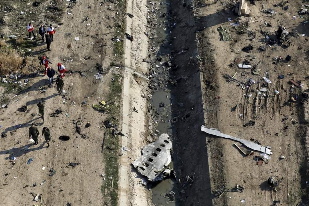 FILE - In this Jan. 8, 2020, file photo, rescue workers search the scene where a Ukrainian plane crashed in Shahedshahr, southwest of Tehran, Iran. The downing of a Ukrainian jetliner near Tehran highlights the limits of the civilian arm of Iran's government against the absolute power of the Shiite theocracy and the paramilitary forces beneath it. 