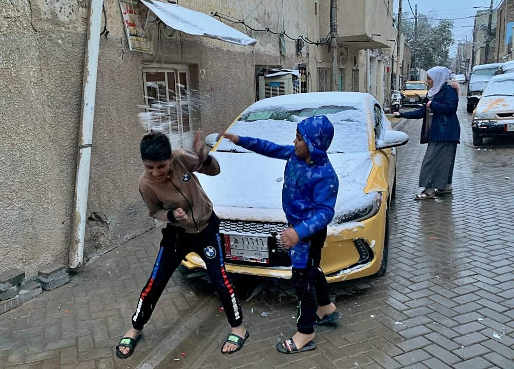Iraqi children play in the snow in Baghdad, Iraq, Tuesday, Feb. 11, 2020.