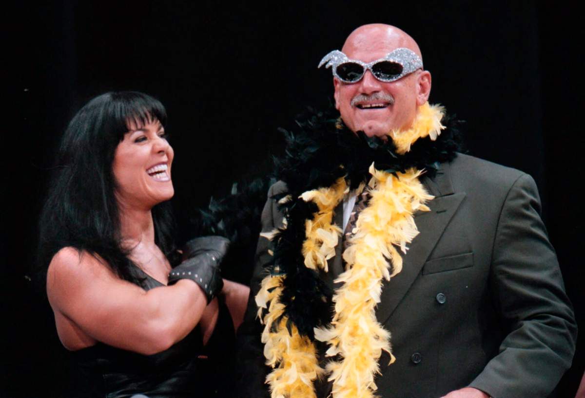 FILE - In this July 14, 1999 file photo, Minnesota Gov. Jesse Ventura is adorned with his signature feather boa and glitter sunglasses by professional wrestler Chyna, during a World Wrestling Federation press conference at the Target Center in Minneapolis.
