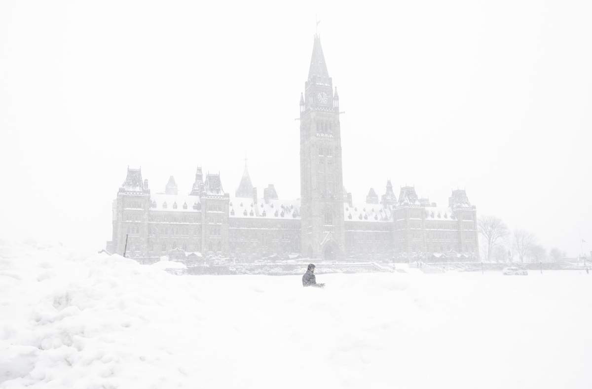 A pedestrian walks past a snowbank on Parliament Hill in Ottawa on Sunday, Jan. 20, 2019.