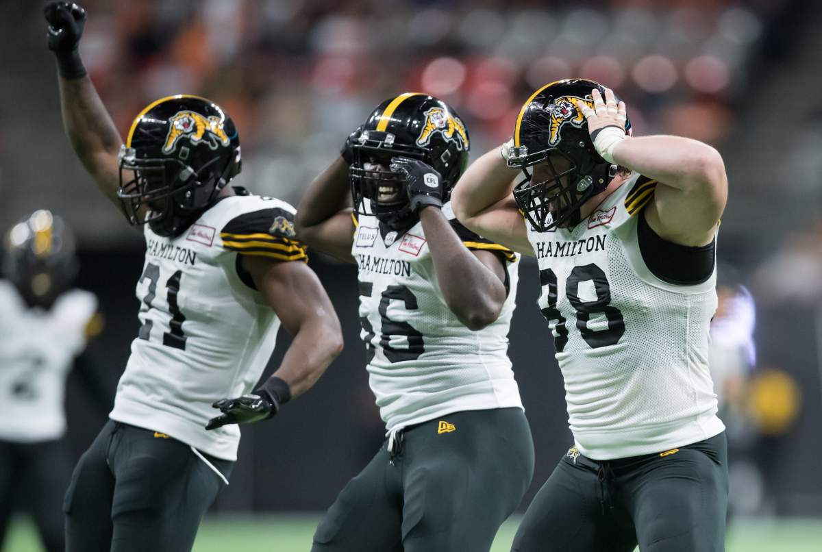 Hamilton Tiger-Cats' Dylan Wynn, front right, Ja'Gared Davis, centre, and Simoni Lawrence celebrate after Wynn sacked B.C. Lions quarterback Mike Reilly during second half CFL football action in Vancouver, Saturday, Aug. 24, 2019. 