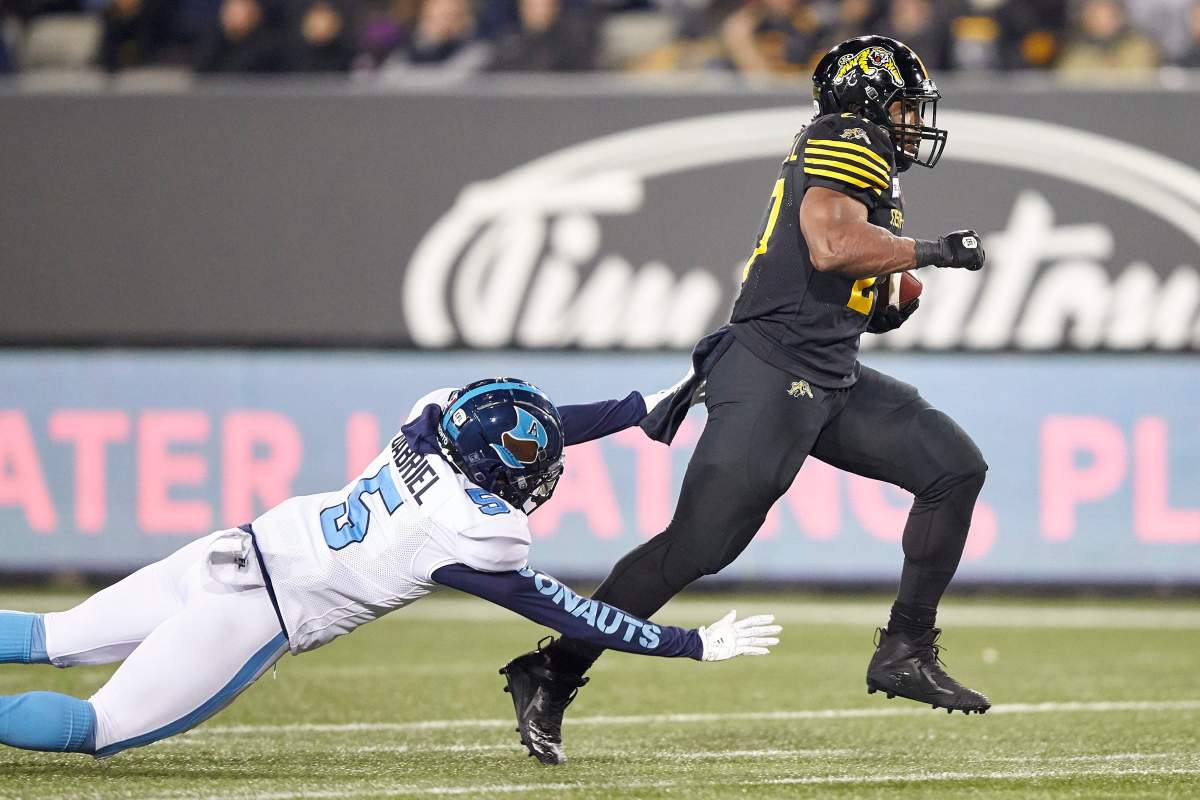 Hamilton’s Cameron Marshall eludes a tackle by Toronto’s Jermaine Gabriel during second quarter CFL action between the Tiger-Cats and the Toronto Argonauts in Hamilton, Ont. on Saturday, Nov. 2, 2019.