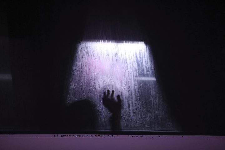 FILE PHOTO: In this Nov. 15, 2019 photo, a migrant puts his hand on the window of a bus in Alvarado, Veracruz state, Mexico. 