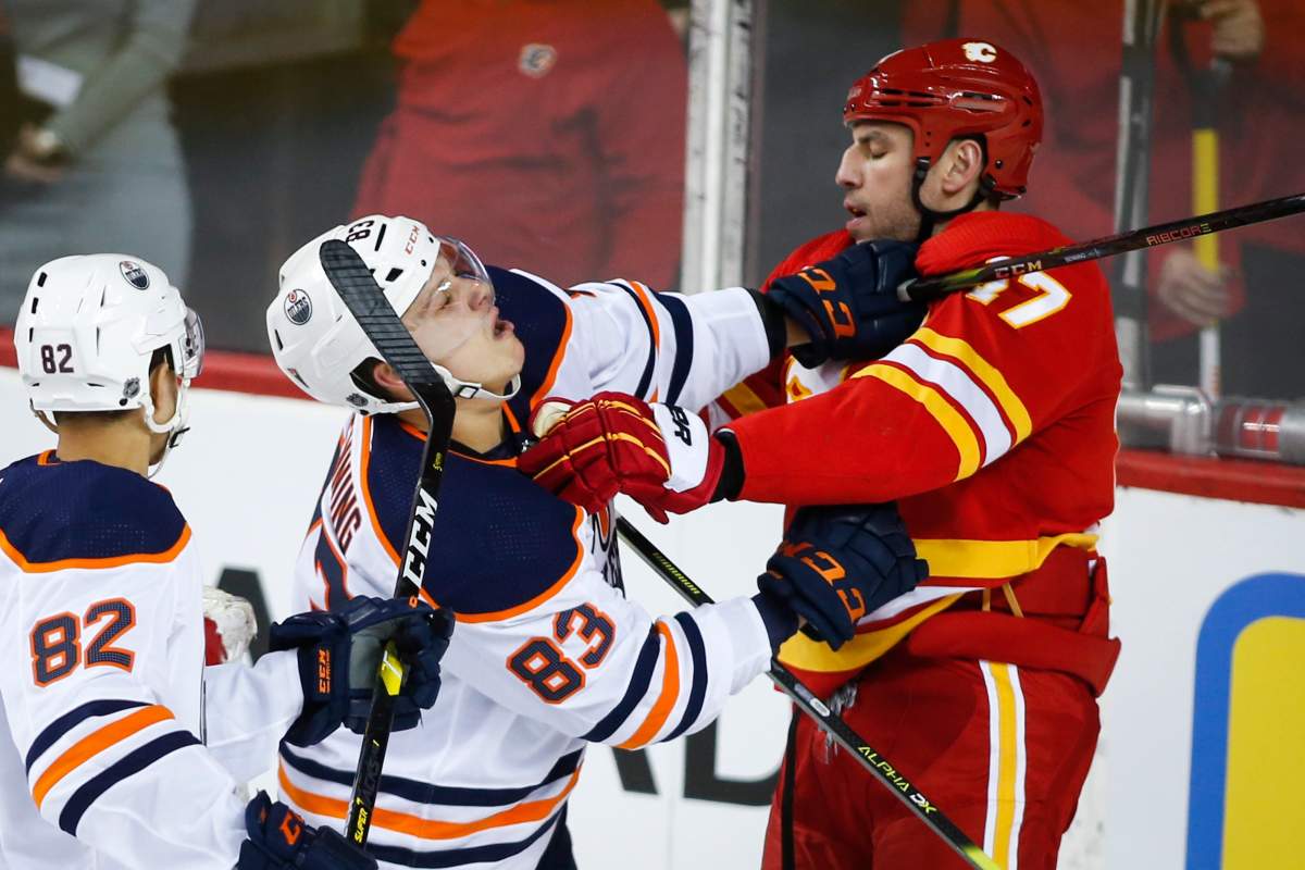 Edmonton Oilers' Matt Benning, left, and Calgary Flames' Milan Lucic scuffle during second period NHL hockey action in Calgary, Saturday, Feb. 1, 2020.THE CANADIAN PRESS/Jeff McIntosh.