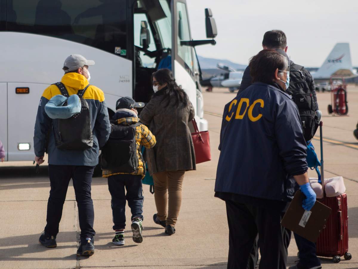 This Feb. 5, 2020, photo provided by the U.S. Department of Health and Human Services shows evacuees from China arriving at Marine Corps Air Station in Miramar, Calif.