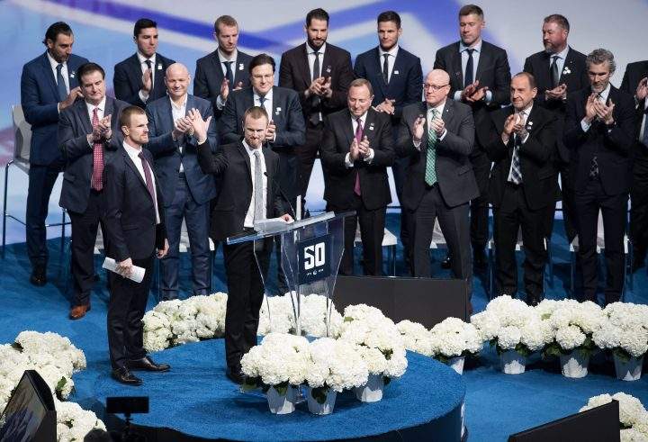 Former Vancouver Canucks players Henrik Sedin, front right, and his twin brother Daniel Sedin, left, both of Sweden, speak during a jersey retirement ceremony before an NHL hockey game in Vancouver, on Wednesday February 12, 2020.