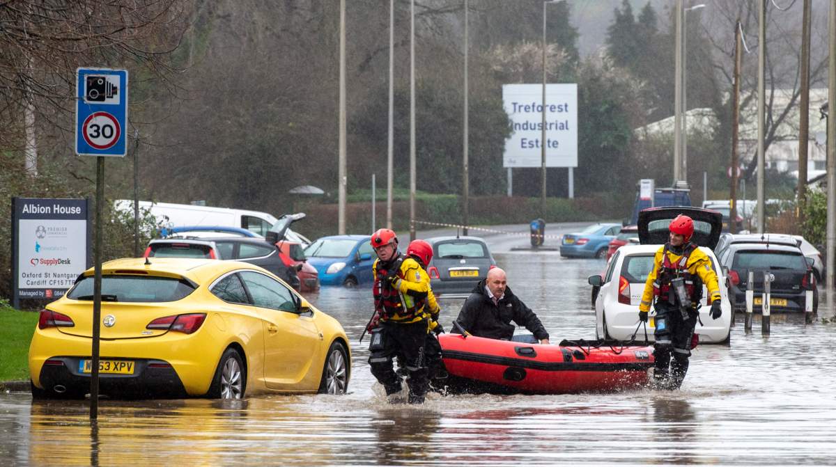 Emergency service officers evacuate a man from a flooded area of Nantgarw village, near Cardiff, South Wales, Britain, on Feb. 16, 2020, after Storm Dennis hit the area last night, bringing torrential rains, floods and landslides.