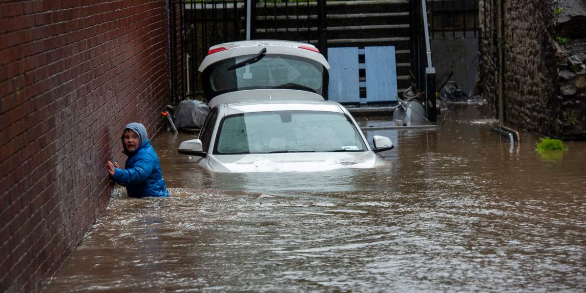 A boy wades towards a flooded alleyway in Pontypridd, South Wales, Britain, on Feb. 16, 2020, after Storm Dennis hit the area last night, bringing torrential rains, floods and landslides.