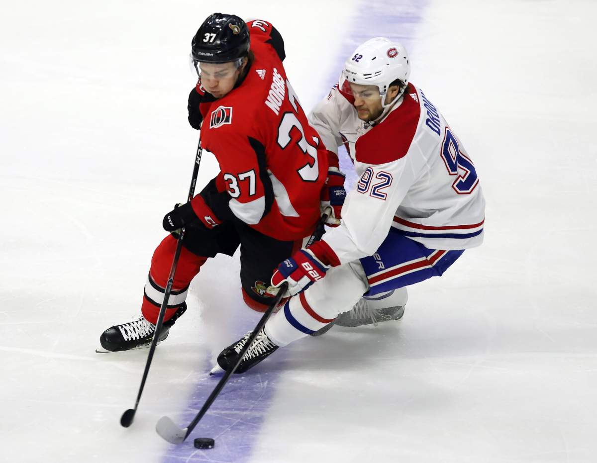 Ottawa Senators centre Josh Norris (37) and Montreal Canadiens left wing Jonathan Drouin (92) battle for the puck during first period NHL action in Ottawa on Saturday, Feb. 22, 2020. 
