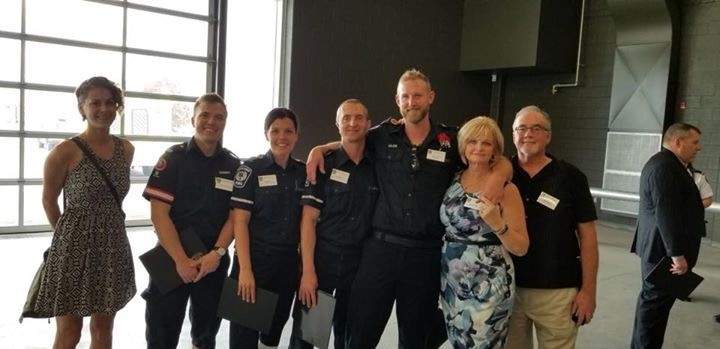 Adam Tapp, with his parents on the right and the crew that saved him on the left at a survivor lunch in London, Ont.