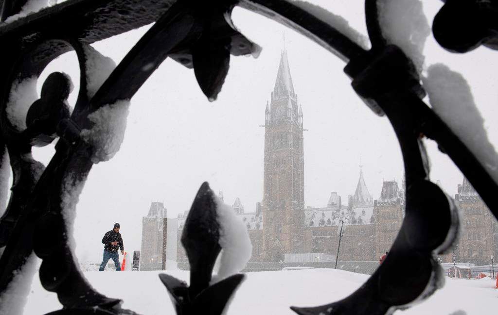A man walks on Parliament Hill during a snow storm in Ottawa, Thursday, Feb. 27, 2020. Over 25cm of snow was expected to fall on the region as a winter storm passed through.