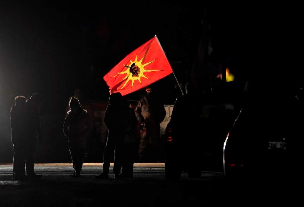 Protesters stand at a rail blockade in Tyendinaga Mohawk Territory, near Belleville, Ont., on Sunday Feb. 23, 2020, during a protest in solidarity with Wet'suwet'en Nation hereditary chiefs attempting to halt construction of a natural gas pipeline on their traditional territories.