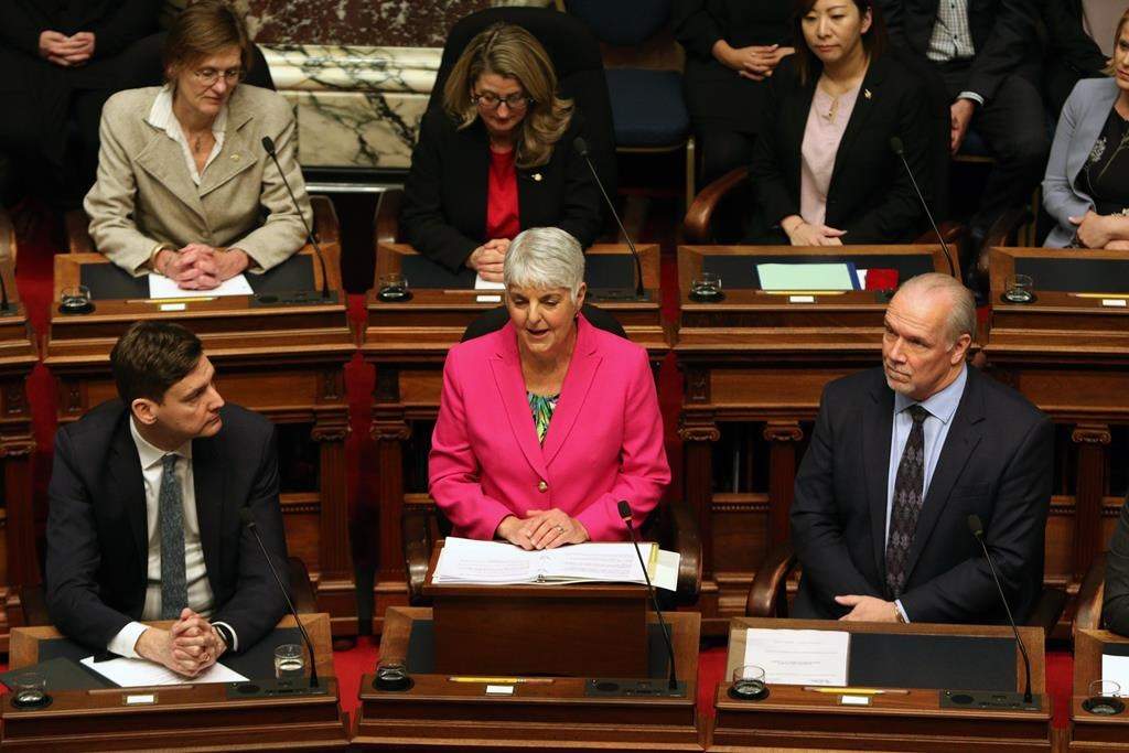Attorney General David Eby and Premier John Horgan look on as Minister of Finance Carole James delivers the budget speech from the legislative assembly at B.C. Legislature in Victoria, B.C., on Tuesday, February 18, 2020.