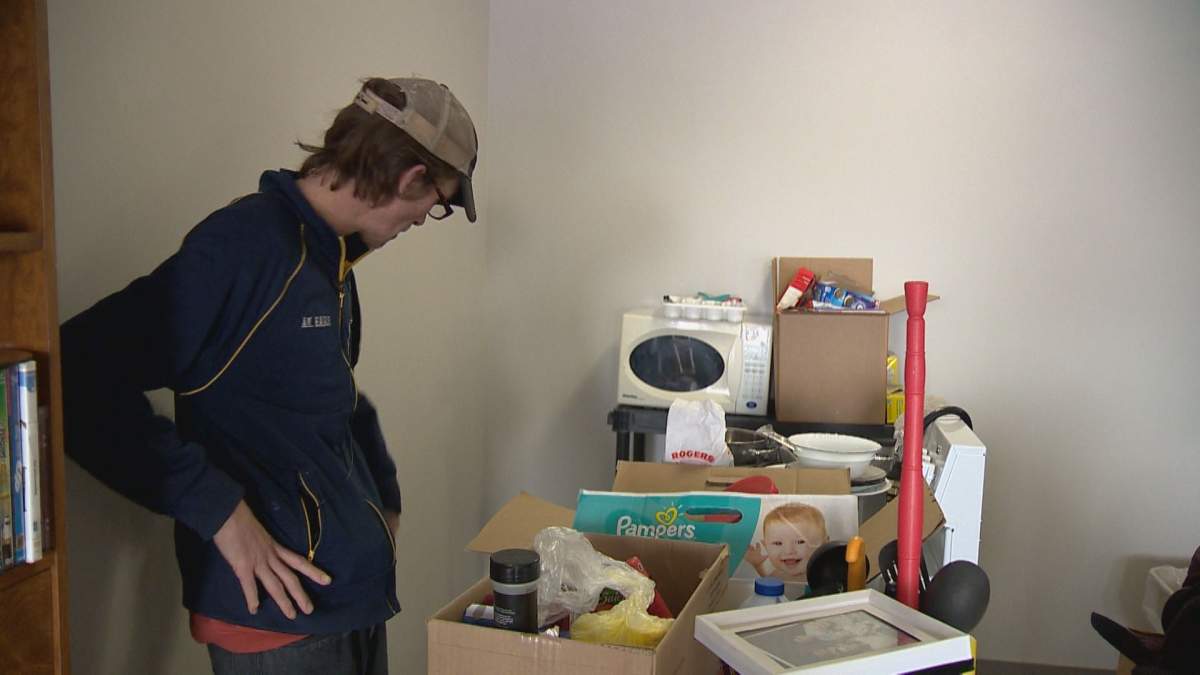 Chris McKenzie stands by a cluster of his belongings that have been moved to allow exterminators to fumigate his apartment.
