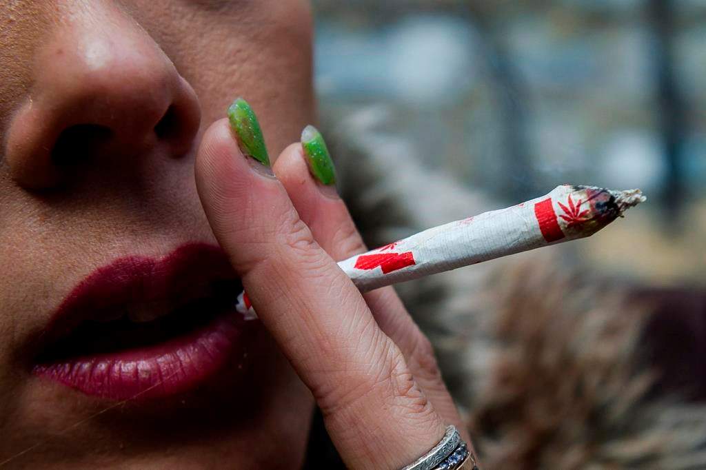 A woman smokes a marijuana joint.