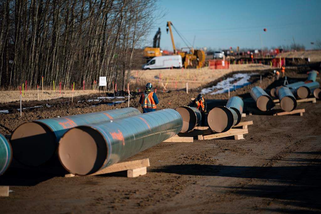Workers place pipe in a handout photo from Trans Mountain.