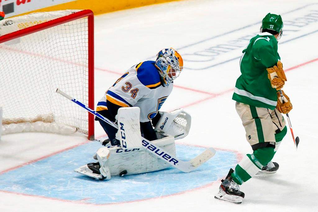 St. Louis Blues goaltender Jake Allen, left, makes a pad save on the shot by Dallas Stars center Andrew Cogliano, right, during the third period of an NHL hockey game in Dallas, Friday, Feb. 21, 2020.