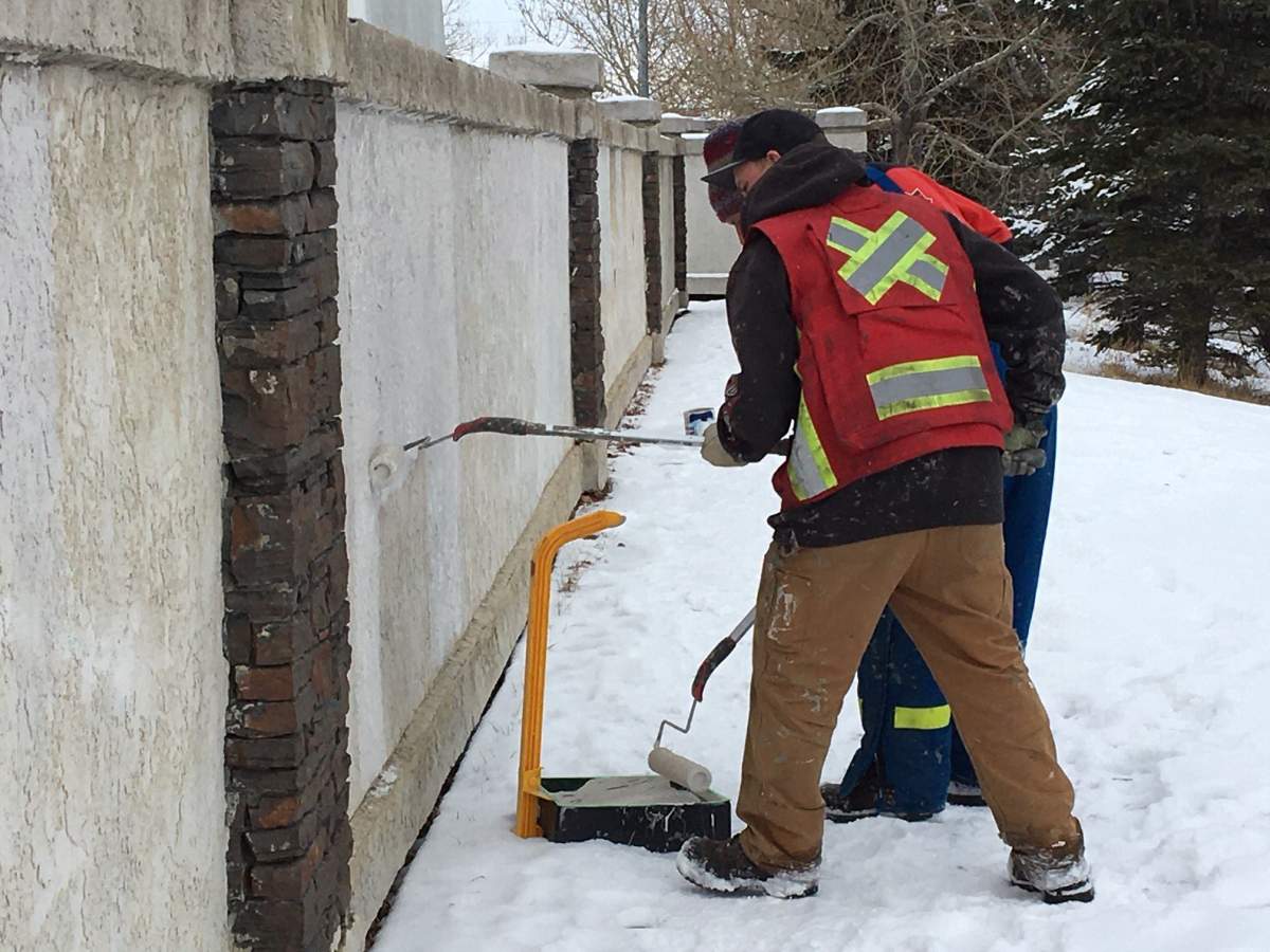 Crews were seen painting over graffiti on a sound barrier wall in Calgary on Tuesday, Feb. 4.