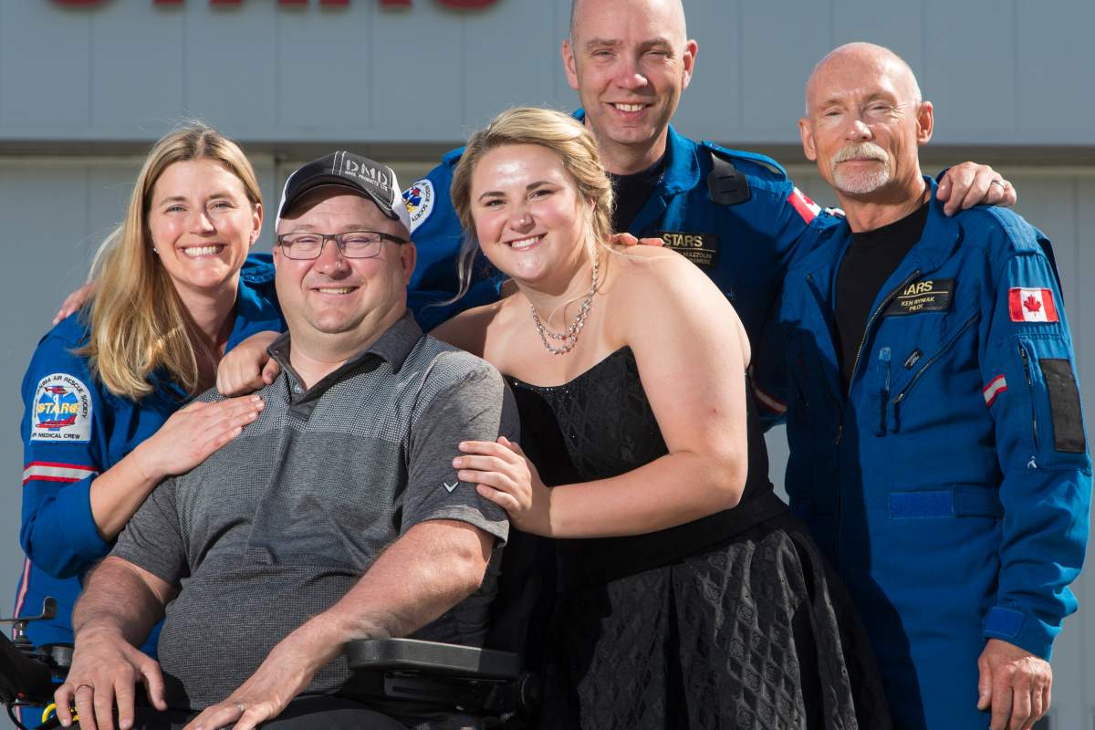 STARS VIP Jason Lunn and daughter Cadence, in her high school grad dress, with flight nurse Lori Coutts, flight paramedic Jusin Mazzolini and pilot Ken Ryniak, photographed on Wednesday, May 16, 2018 Place: Edmonton, Alberta, STARS hangar Photographer: Lyle Aspinall Original: Jason Lunn_R8A5278.JPG