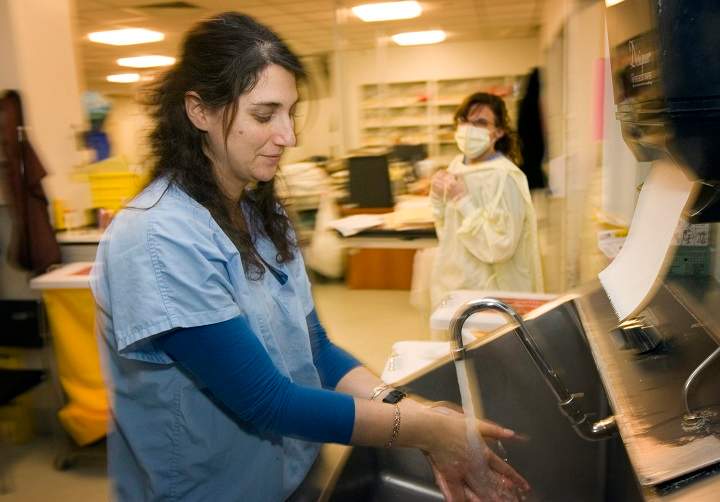 In this file photo, nurse Elana Cohen washes her hands prior to tending to patients as colleague Julie-Anne D'Amico looks on in the intensive care unit at the Montreal Jewish General hospital. The hospital is one of four designated to treat any future patients diagnosed with coronavirus. Friday, Feb. 7, 2020.