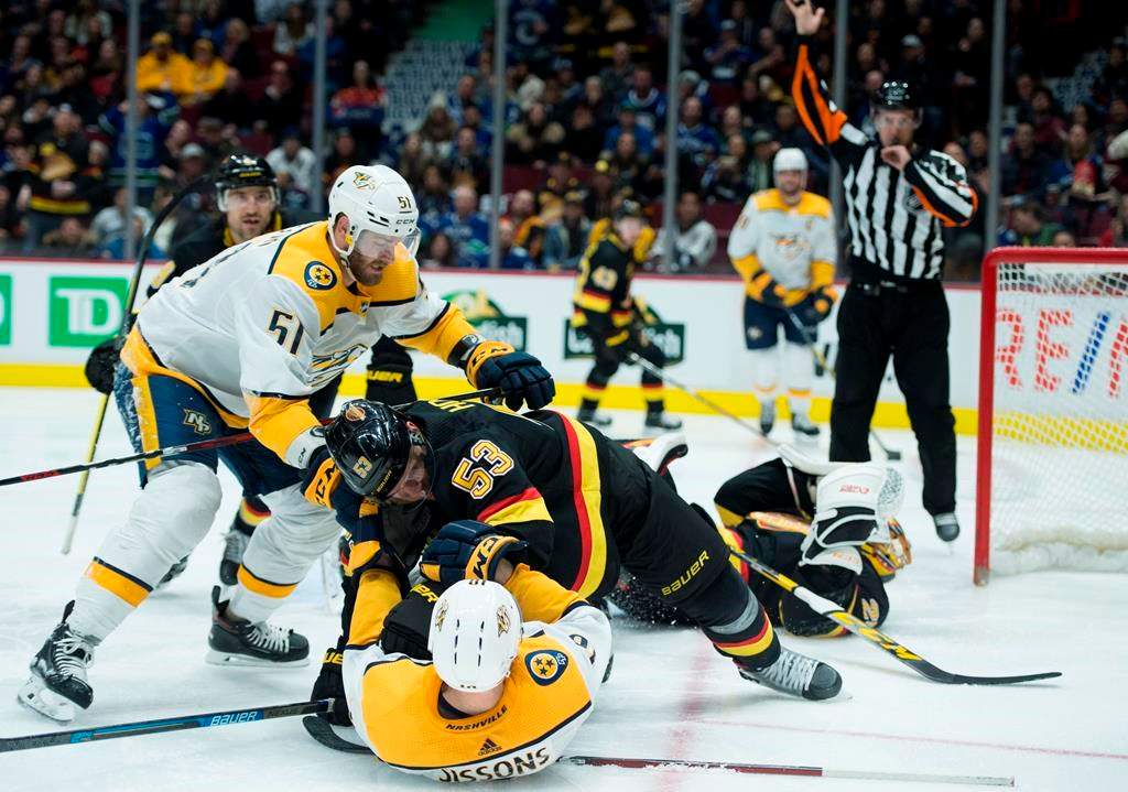 Nashville Predators left wing Austin Watson (51) looks on as Vancouver Canucks centre Bo Horvat (53) puts Nashville Predators centre Colton Sissons (10) to the ice during third period NHL action in Vancouver, Monday, February 10, 2020. THE CANADIAN PRESS/Jonathan Hayward.