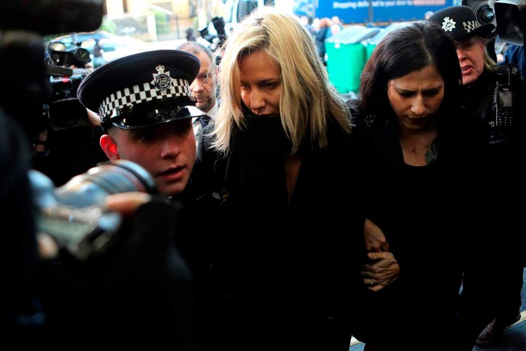 In this file photo dated Monday, Dec. 23, 2019, ‘Love Island’ TV presenter Caroline Flack, centre, is escorted by police as she arrives at court in London, England after being charged with assault of former professional tennis player and model Burton.
