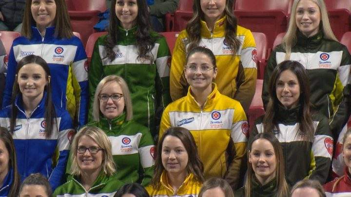 Curlers from across the country pose for a group photo at Mosaic Place during the opening ceremony for the Scotties Tournament of Hearts.