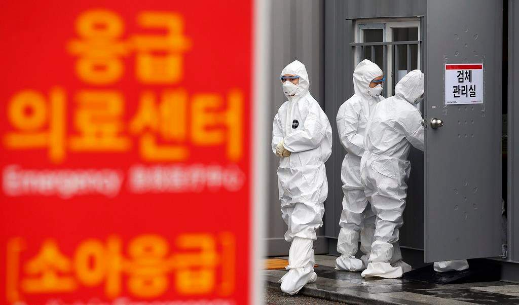 Officials wearing protective attire work to diagnose people with suspected symptoms of the new coronavirus at a hospital in Daegu, South Korea, Wednesday, Feb. 26, 2020.
