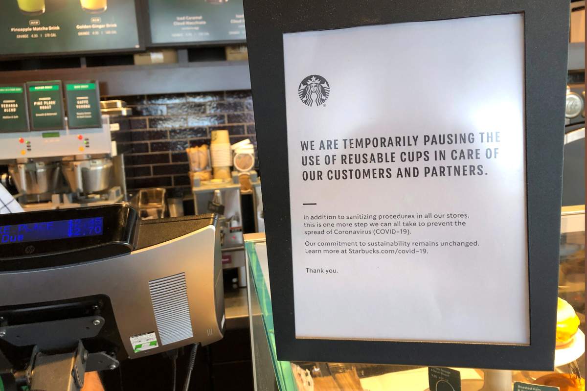 A sign posted at a Starbucks store in Tacoma, Wash., Thursday, March 5, 2020, tells customers that the coffee company is temporarily stopping accepting reusable cups, as part of efforts to prevent the spread of the COVID-19 coronavirus.