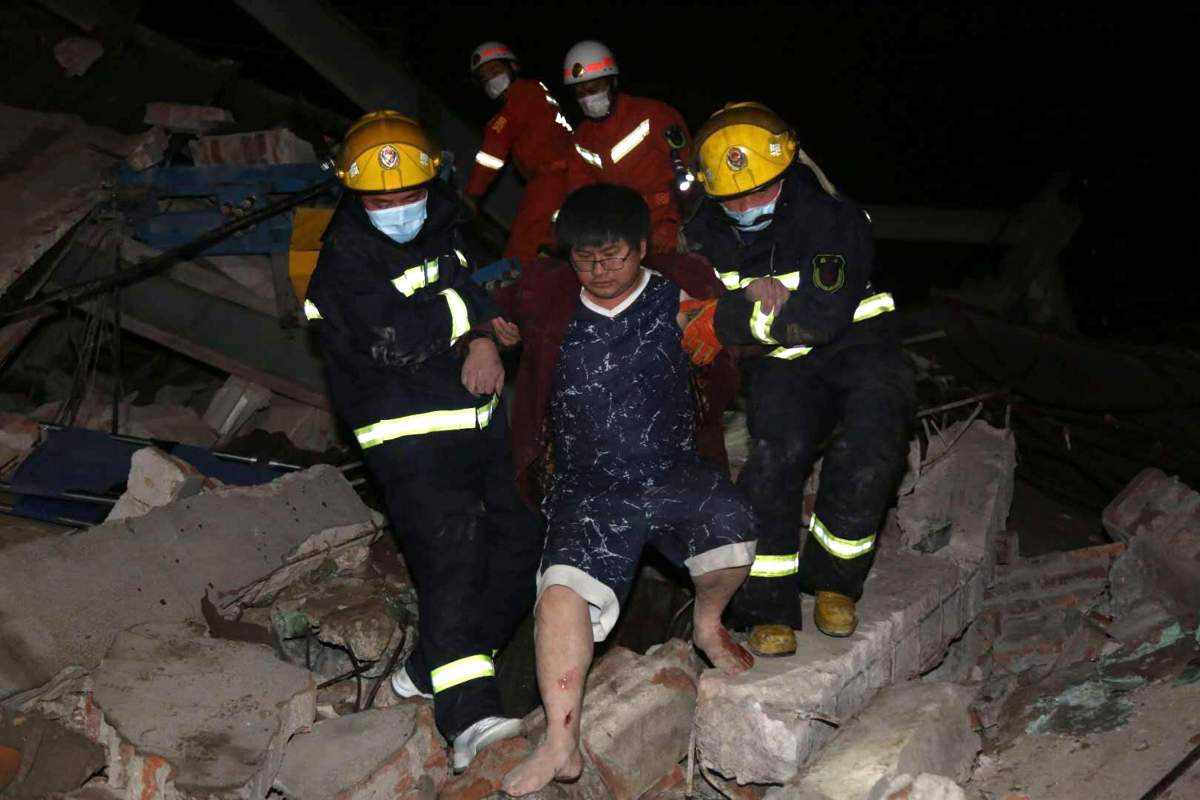 Rescuers help a man from the rubble of a collapsed hotel building in Quanzhou city in southeast China’s Fujian province March 7, 2020.