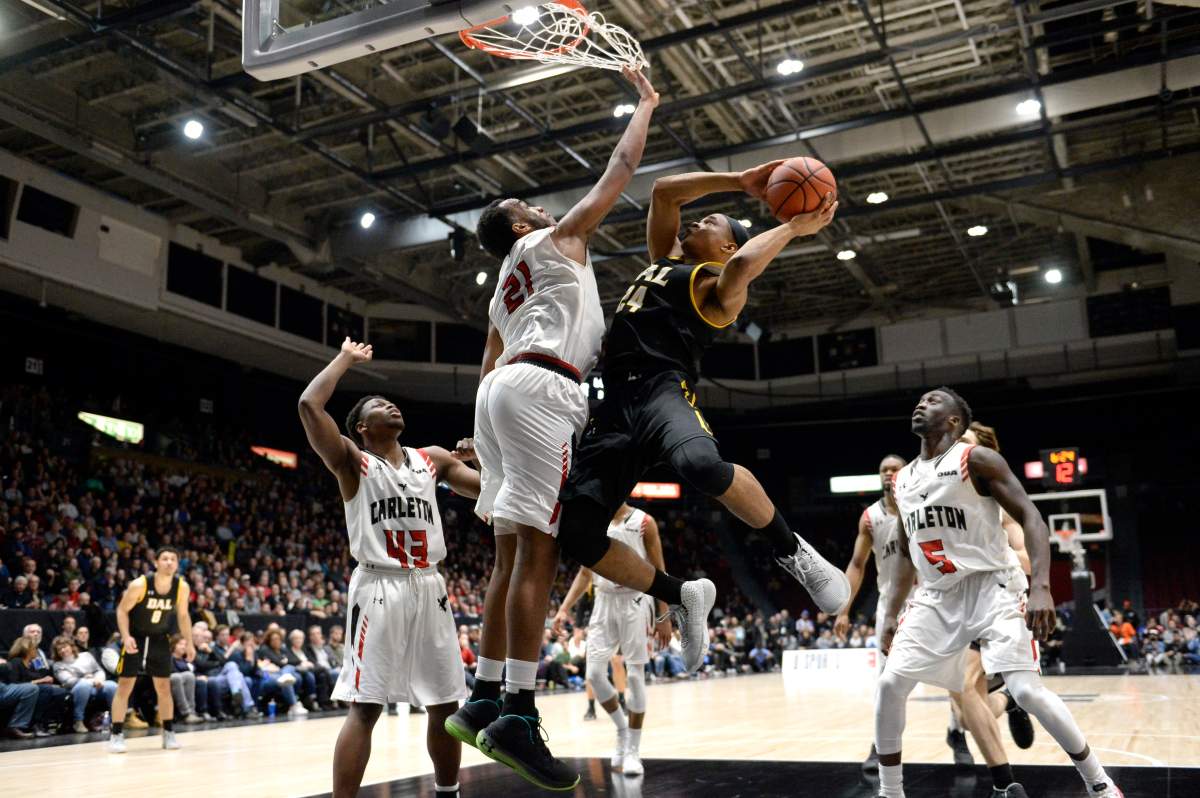 Dalhousie Tigers guard Shamar Burrows (24) tries to get a shot past Carleton University Ravens’ Biniam Ghebrekidan (21) during the second half of the men’s championship final basketball game of the U Sports Final 8 Championships, in Ottawa, on Sunday, March 8, 2020. THE CANADIAN PRESS/Justin Tang
