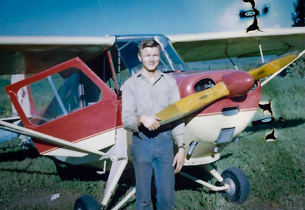 Richard Reid, at 18-years-old, stands beside his first airplane on July 1, 1969, at the family farm near Cremona, Alta.