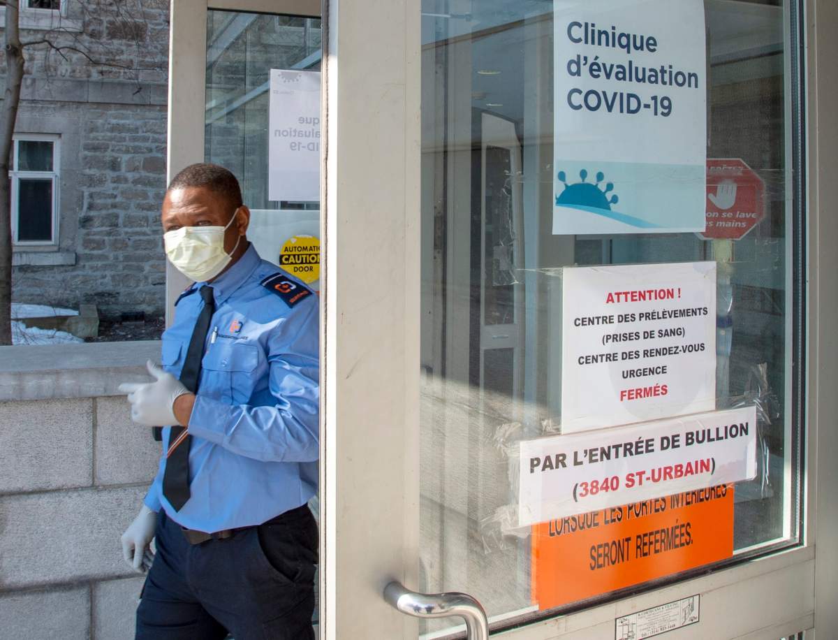 In this March 2020 file photo, a security guard wears a protective mask in front of the new COVID-19 clinic at the site of the former Hôtel-Dieu hospital, The hospital is once again welcoming patients. Tuesday, Oct. 20, 2020.