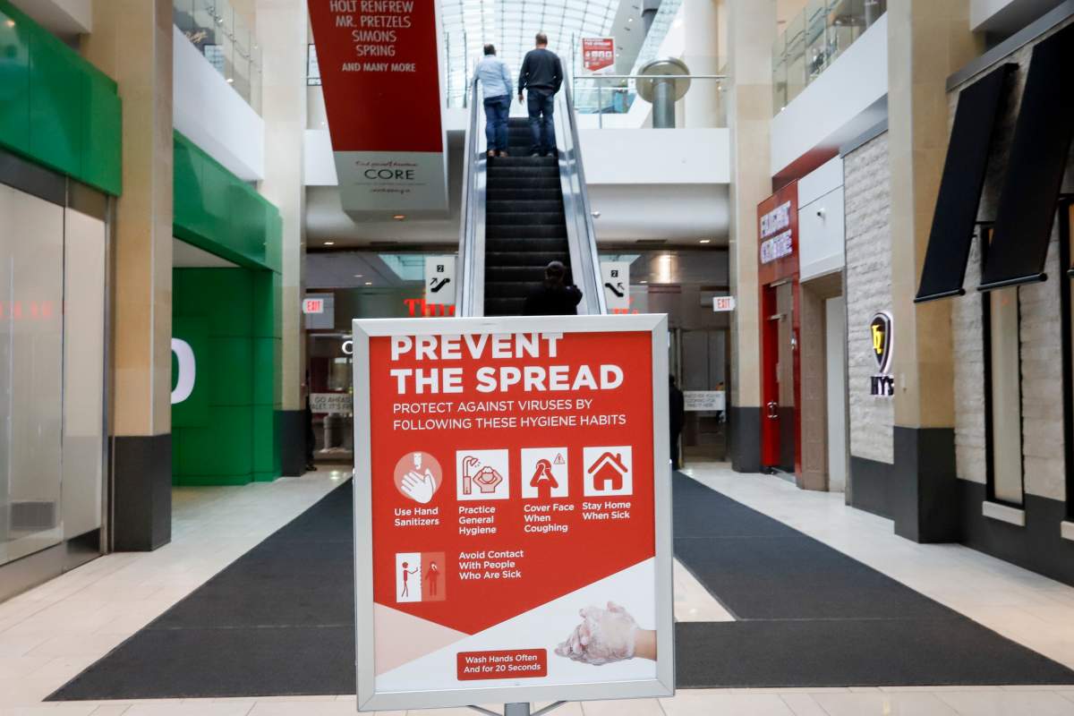Shoppers take an escalator in an empty shopping mall in Calgary, Alta., Wednesday, March 18, 2020, amid the worldwide COVID-19 pandemic.
