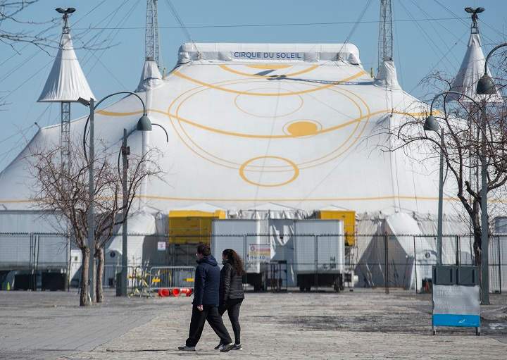 A man and woman walk by the Cirque du Soleil Big Top in Montreal's Old Port, Saturday, March 21, 2020, as COVID-19 cases rise in Canada and around the world.