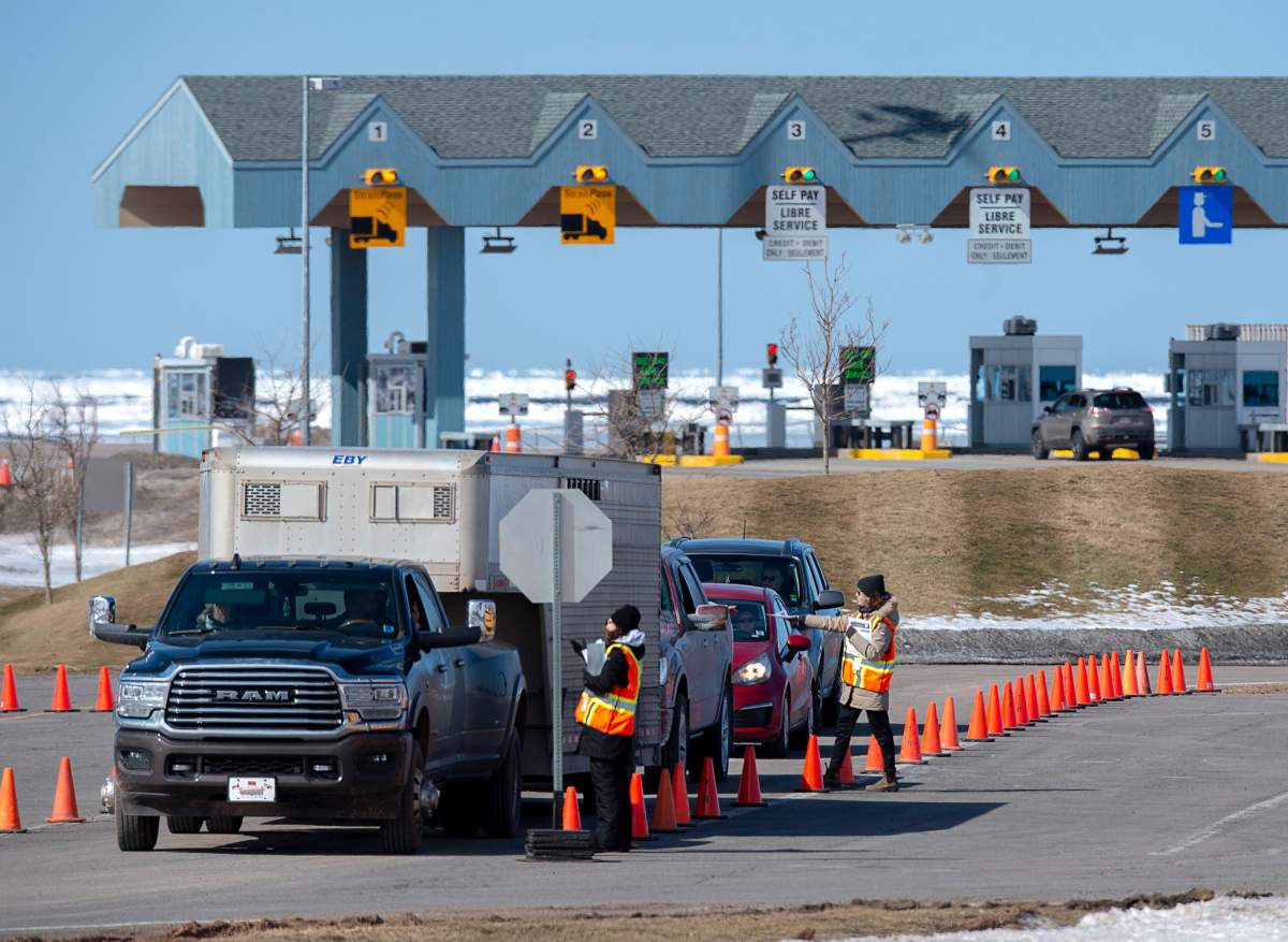 Provincial health department workers stop traffic that has crossed the Confederation Bridge in Borden-Carleton, P.E.I. on Sunday, March 22, 2020. Anyone arriving on Prince Edward Island from another province is told to self-isolate for 14 days.