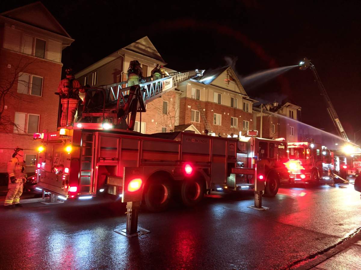 Ottawa firefighters battle a blaze that broke out in a row home complex on Barnstone Drive in Barrhaven on March 31, 2020.