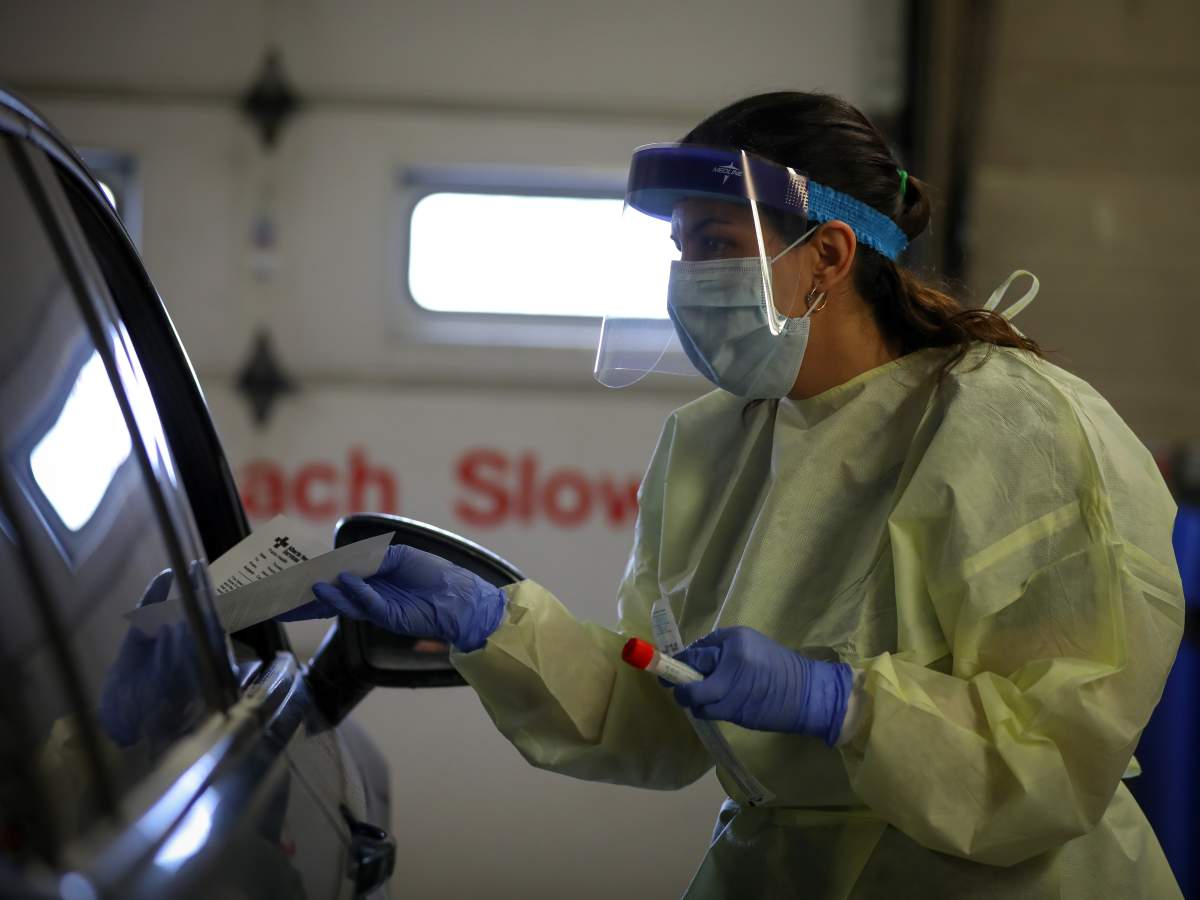 An AHS worker administering a COVID-19 test at a drive-thru assessment centre in Calgary, Alta. 