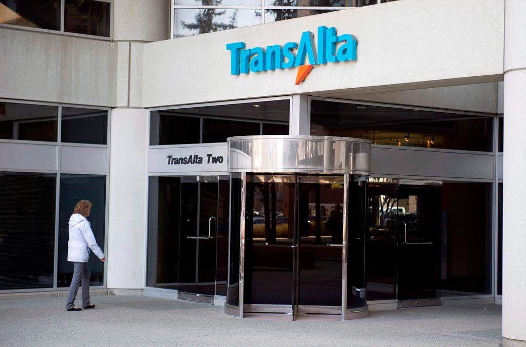 A woman walks towards the entrance of the TransAlta headquarters building in Calgary, on Tuesday, April 29, 2014.