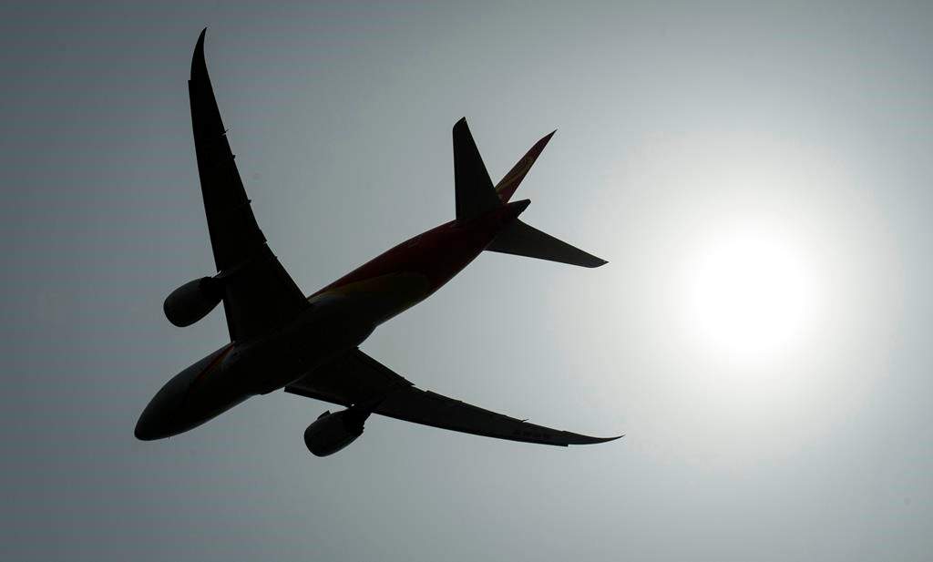 A plane is silhouetted as it takes off from Vancouver International Airport in Richmond, B.C., on May 13, 2019.