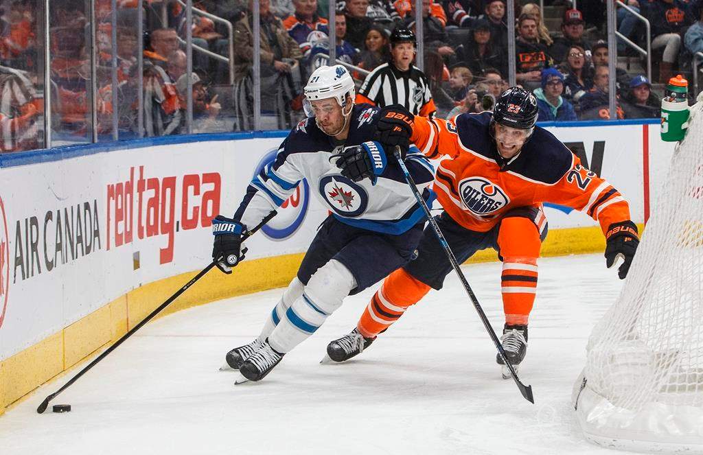 The Winnipeg Jets' Nicholas Shore is chased by Edmonton Oiler Riley Sheahan during third-period NHL action in Edmonton, Alta., on Wednesday, March 11, 2020.