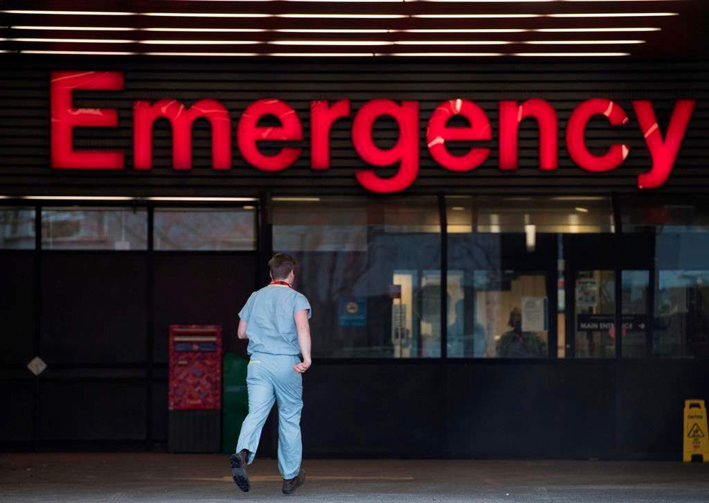 A health-care worker is seen making his way into the emergency department of the Vancouver General Hospital in Vancouver Monday, March 30, 2020.