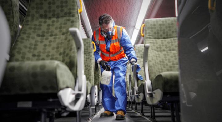 A GO bus is cleaned by a crew member in this handout photo.