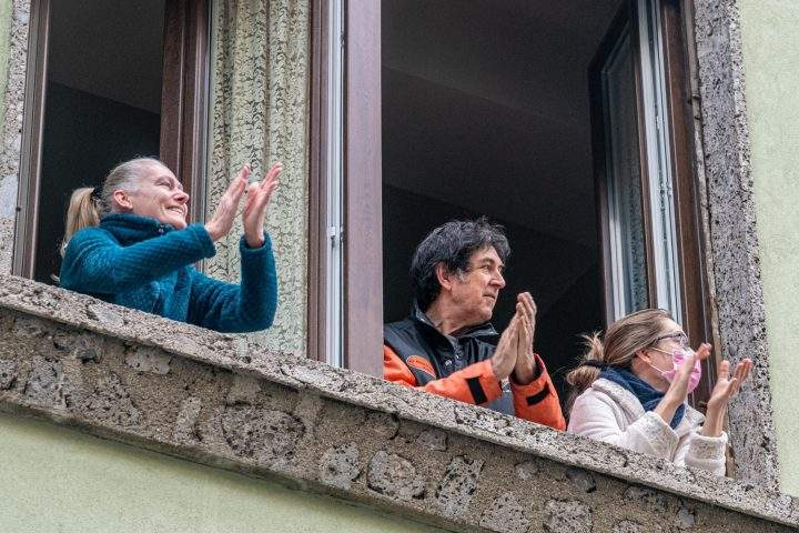 Italians in Milan applaud the efforts of doctors on March 14, 2020.
