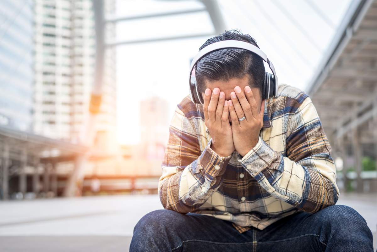 A man trying to alleviate stress listening to music.