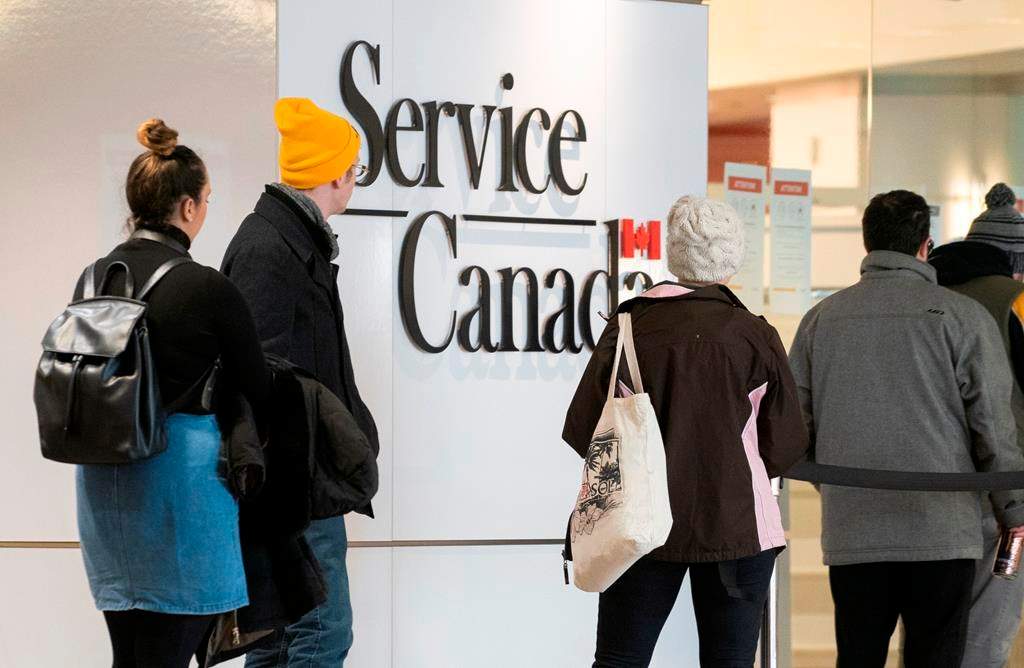 People line up at a Service Canada office in Montreal on Thursday, March 19, 2020. Canadians who have lost their jobs due to COVID-19 and are struggling to make ends meet anxiously awaited promised federal help with the Senate set to take up an emergency $82-billion financial package passed by the House of Commons on Wednesday.