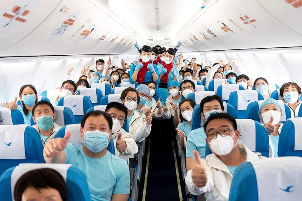 Dozens of healthcare workers are shown on a flight from China to the Philippines.