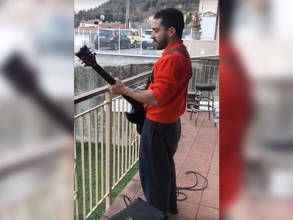 Enrico Monti, a quarantined Italian man, playing guitar on his balcony in Cesena, Italy on March 13, 2020, in the midst of the country's nationwide lockdown, during the COVID-19 outbreak.